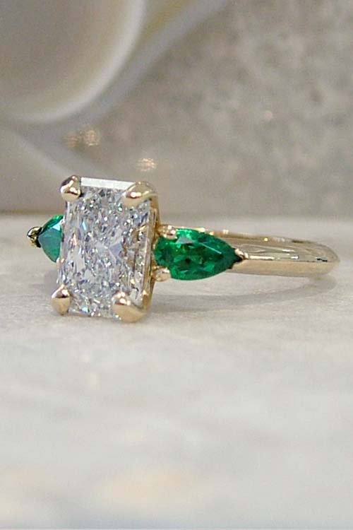 radiant lab grown diamond and emerald engagement ring
